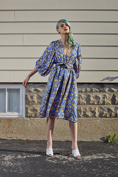 Cynthia Rowley 2019 Resort Collection features a mid-length, belted royal blue and yellow printed dress with flowing sleeves. 