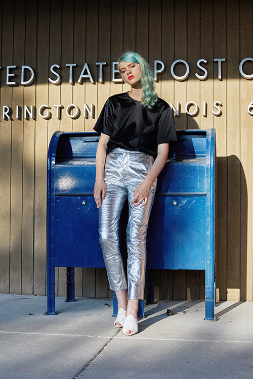 Cynthia Rowley 2019 Resort Collection features high-waisted silver metallic pants paired with a silky, black, scooped neck top.
