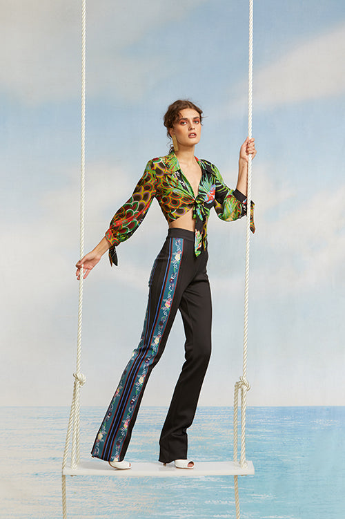 Cynthia Rowley Spring 2018 Look 29 featuring a cropped printed long sleeve tie top and bonded neoprene flare pant with floral print stripe down one leg