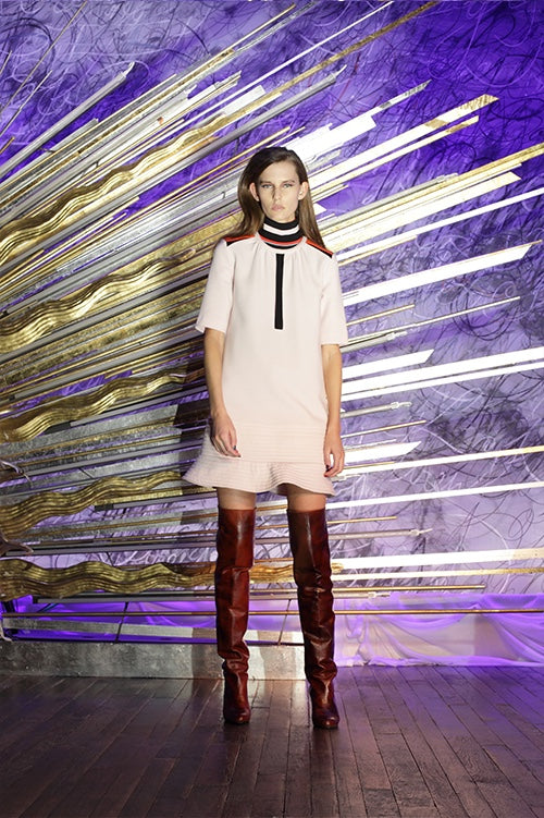 Cynthia Rowley Fall 2014 look 14 featuring a pale pink elbow length sleeve mini dress with black stripe on center front and black white red and orange stripe detail on shoulders and collar with ruffle hem