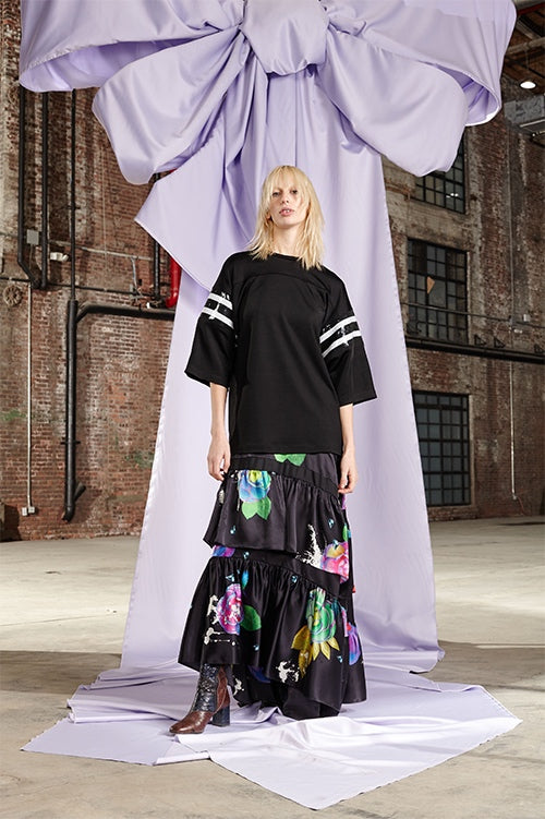 Cynthia Rowley Fall 2017 Look 1 featuring an oversize jersey t-shirt with black and white sequin stripes on sleeves and dark floral print silk charmeuse tiered maxi skirt
