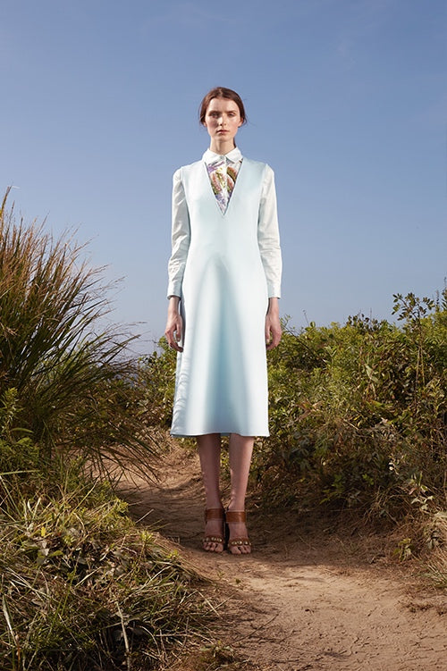 Cynthia Rowley Spring 2016 look 17 featuring a light green bonded neoprene v-neck knee length dress worn over a light green cotton button down shirt with sequin embellishments 