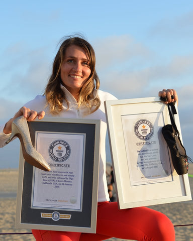 Olga Henry holding her 2x Guinness World Record awards for slacklining.