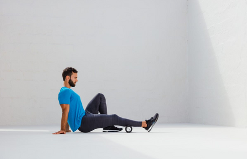 Man rolling his calves out with the BLACKROLL Booster Set