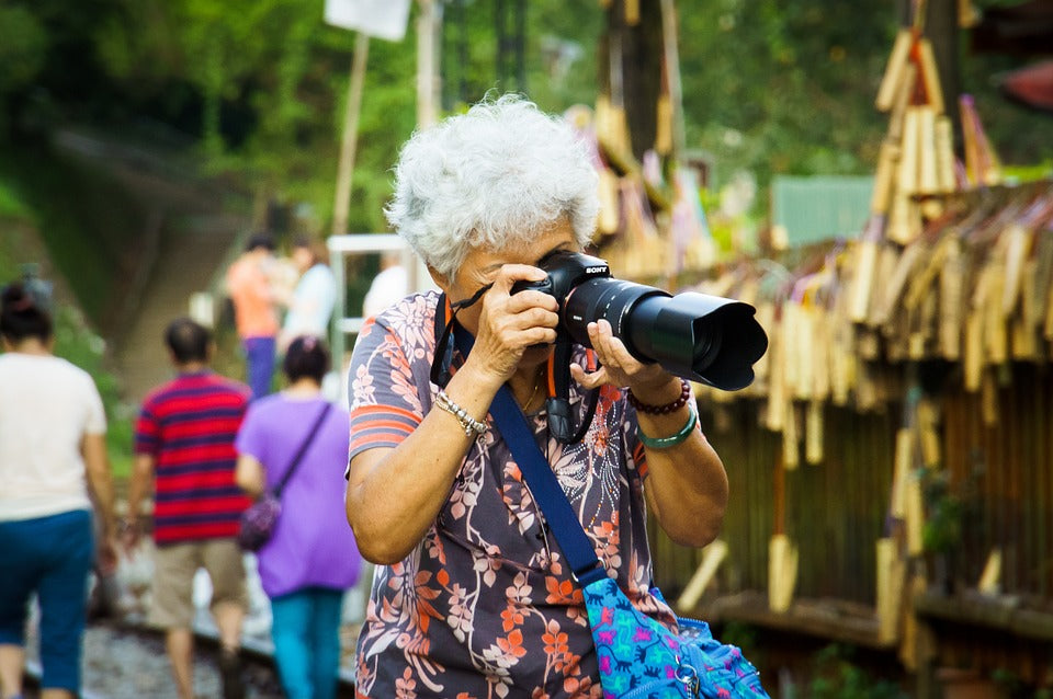 old woman taking picture outdoors