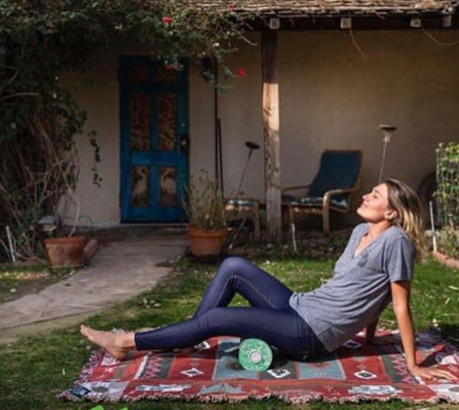 Olga Henry using the BLACKROLL BOOSTER foam roller on her thigh.