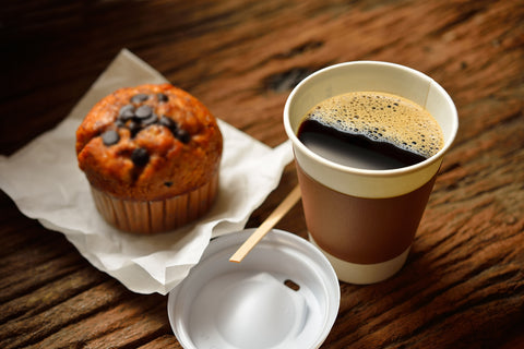Coffee and a muffin on a wooden table background.