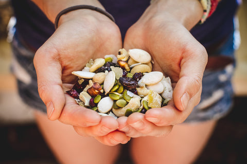 A hiker holds out a handful of homemade trail mix. 