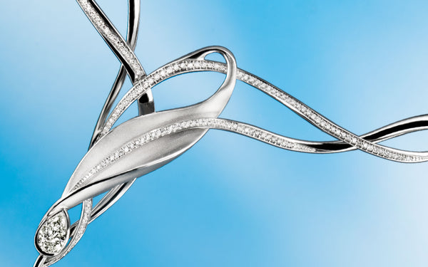 Artistic, complex shape designed jewellery parts, highlighted by line of sparkling briliant cut diamonds