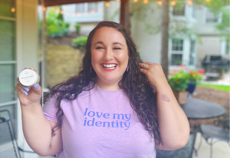 Alysse holds the Salve, smiling in a "Love my identity" t-shirt