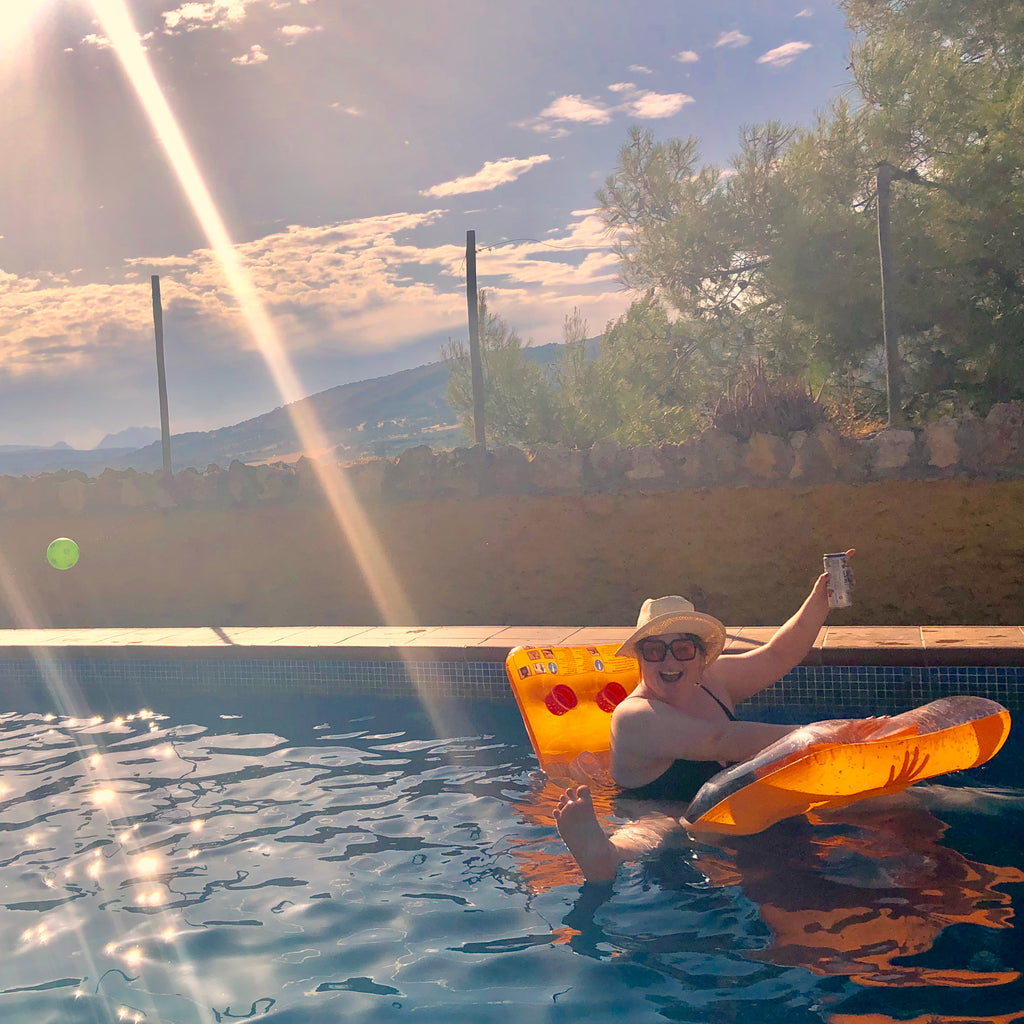 Joeley waves from a pool floatie in a swimming pool