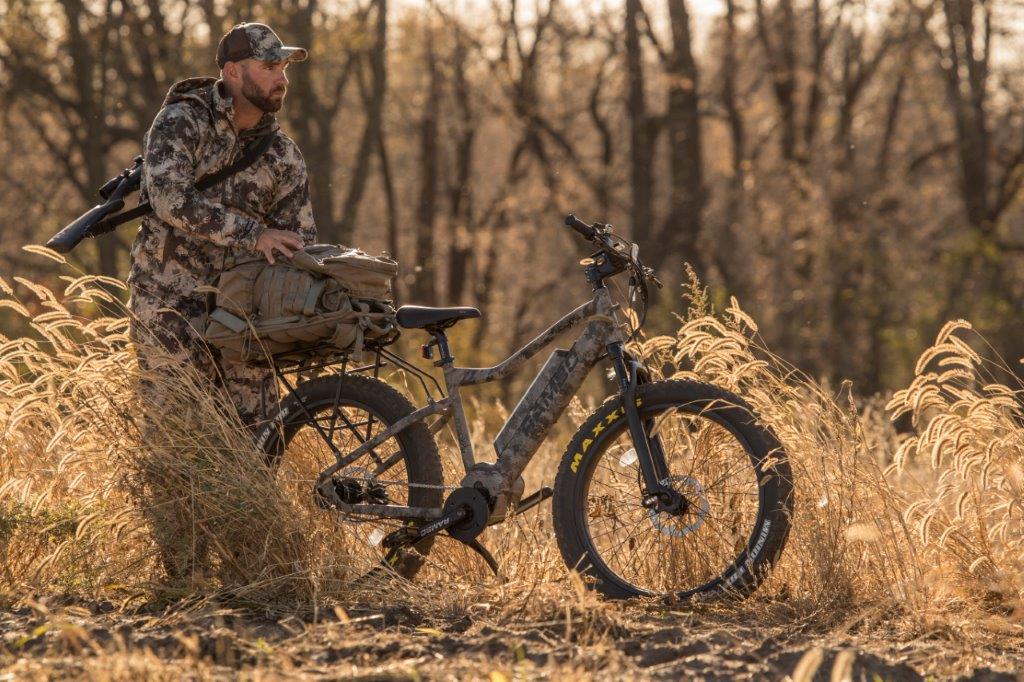 Rambo Bushwacker in the woods with rider standing beside the bike