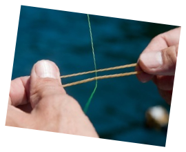 Place the rubber band on either side of the fishing line with a loop in each hand