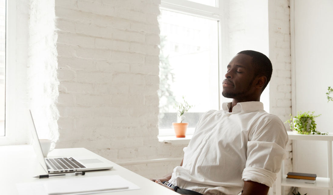 closed eyes in thought at desk