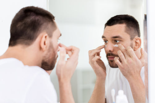 man applying under eye cream