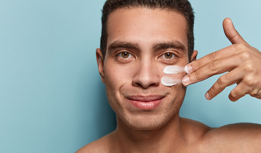 man applying sunscreen to face