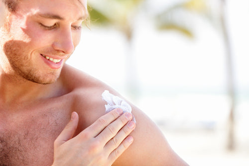 man putting sunblock