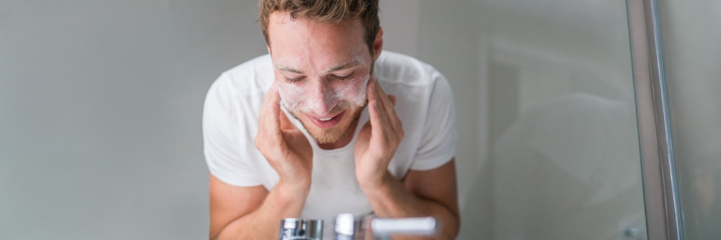 Man washing his face with an exfoliating scrub 