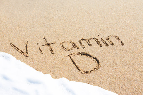 vitamin d written in beach sand