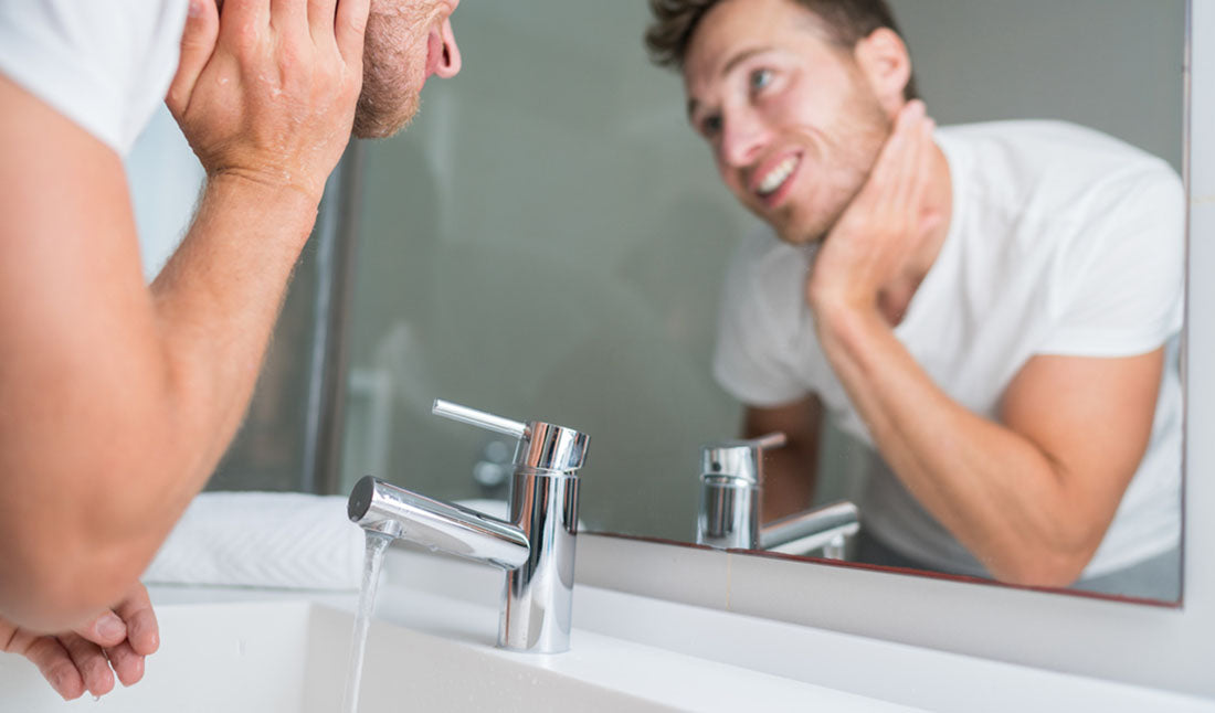man washing face over sink
