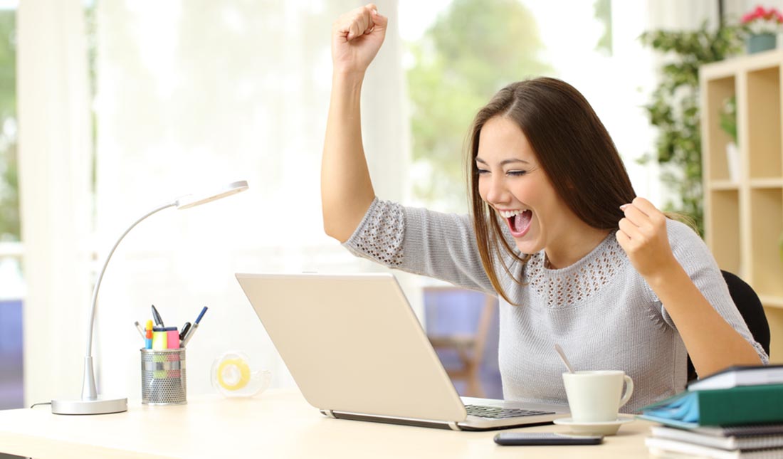 woman cheering at computer screen