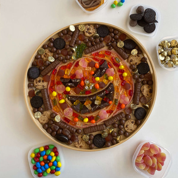 Halloween candies arranged into a scary pumpkin on a tray 