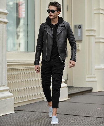homme portant un une veste noir sur un hoodie noir streetwear