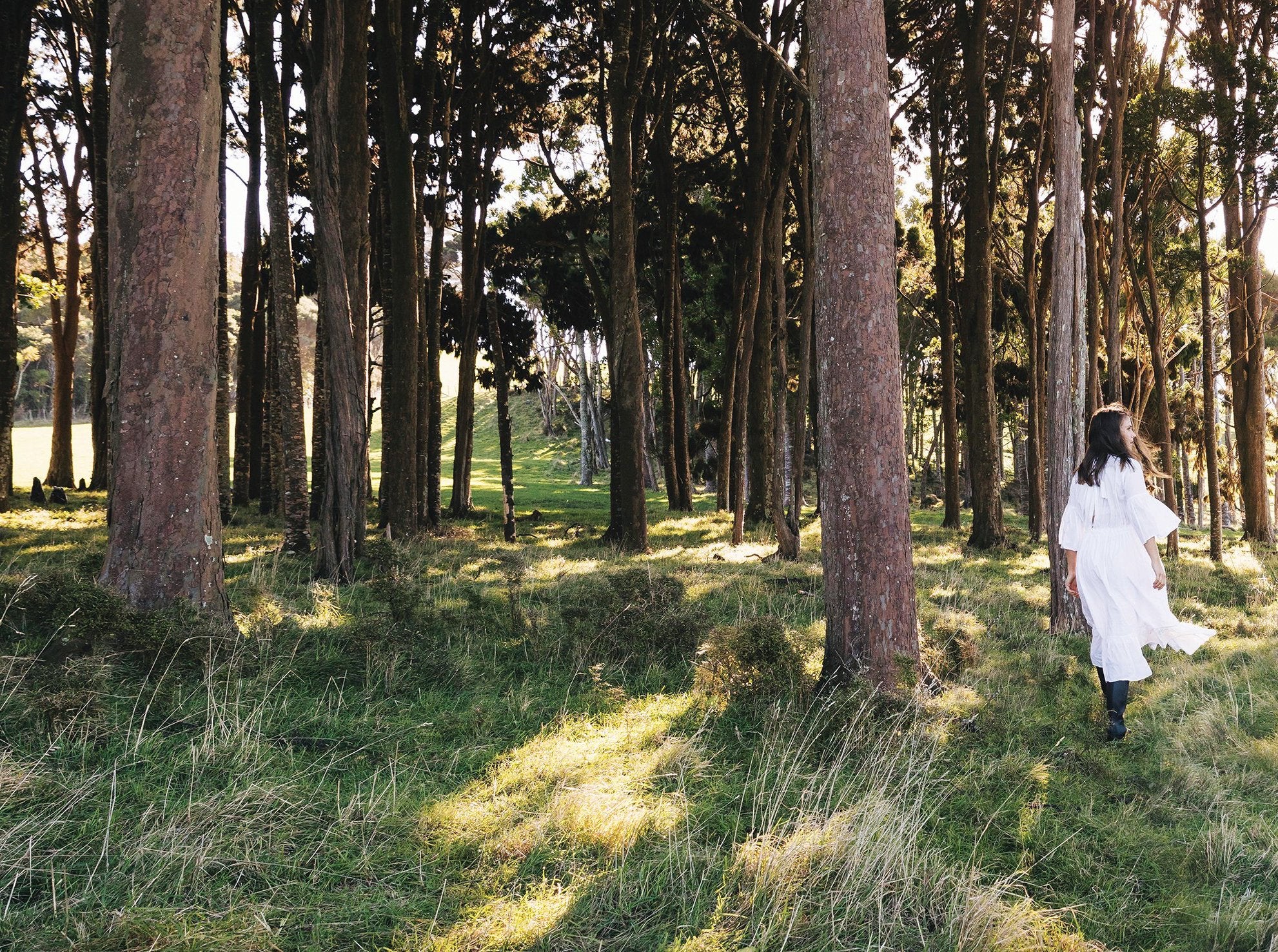 Woman in white dress walking in calm forest