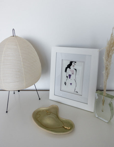 bedside table with ceramic plate and necklace