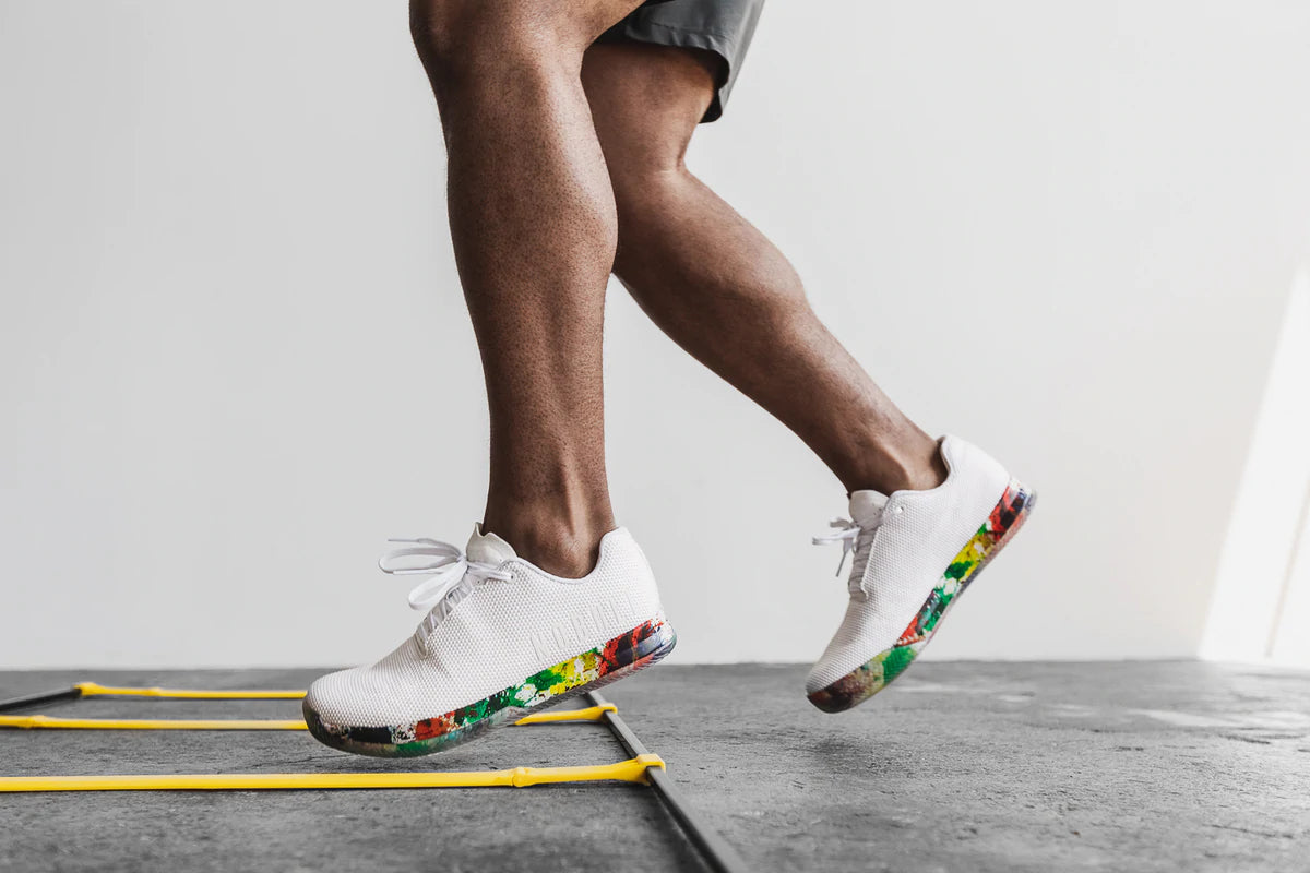 athlete wearing pride art work white court trainer