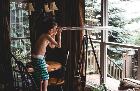 kid looking through telescope