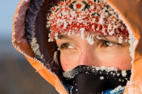 Blonde girl bundled up eye tearing up because it is so cold