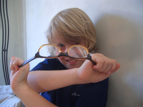 kid trying to stretch out the spring hinges on his sunglasses