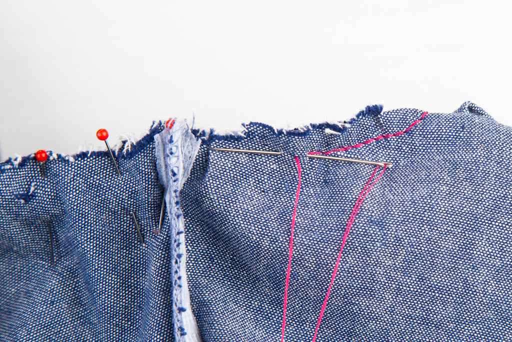 backstitch with red thread on denim fabric