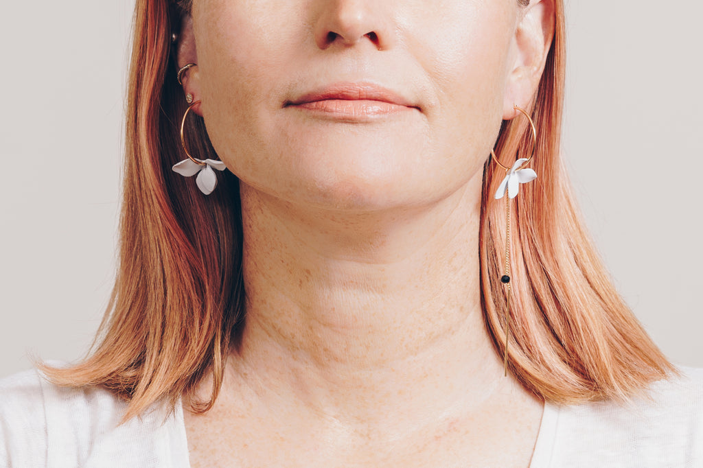 pink hair model wearing mismatched flower hoop dangle earrings by janna Conner
