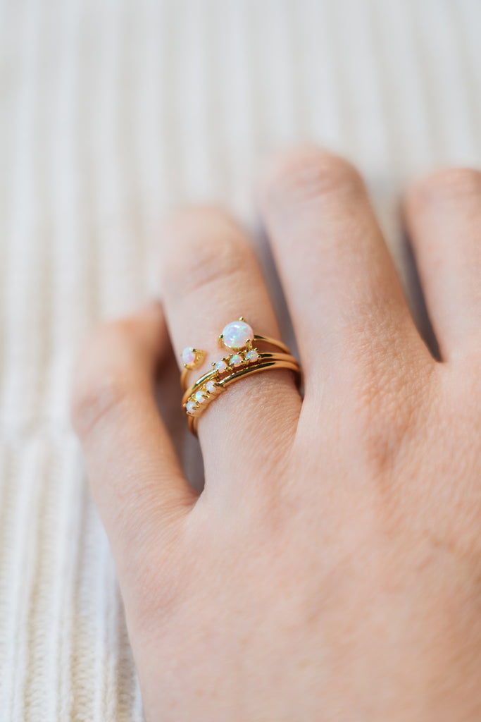 opal stacking ring and gold stacking rings on hand