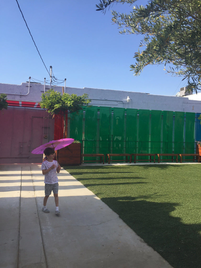 child with parasol walking at purple garden at Underground Museum LA