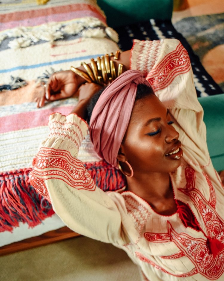 Paola in headwrap and print bedspread with hoop earrings by janna Conner