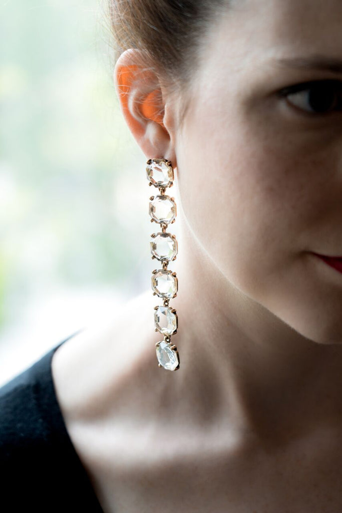 model wearing long shoulder duster crystal drop earrings backlit