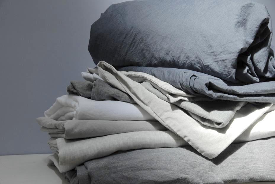 caring for your linens pile of sheets