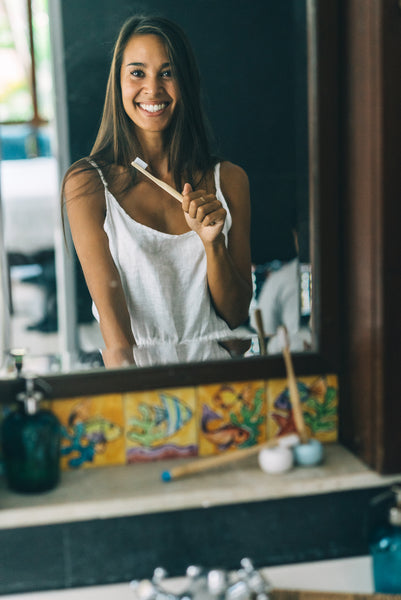 Girl brushing her teeth with a BAMWOO bamboo toothbrush