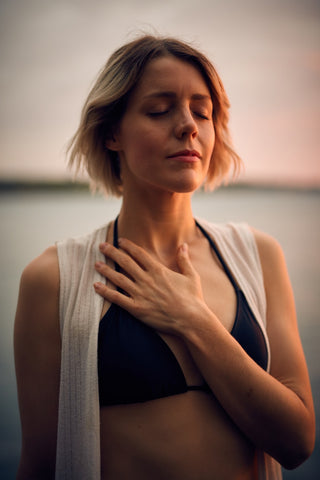 Blonde Woman Concentrates in Grounding as she learns How to Find Time to Meditate On The Go with Adelie Skincare blog