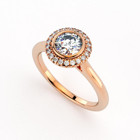 Christine Alaniz Designs rose gold engagement ring with a round brilliant diamond in a bezel setting, a pavé halo, and a plain shank