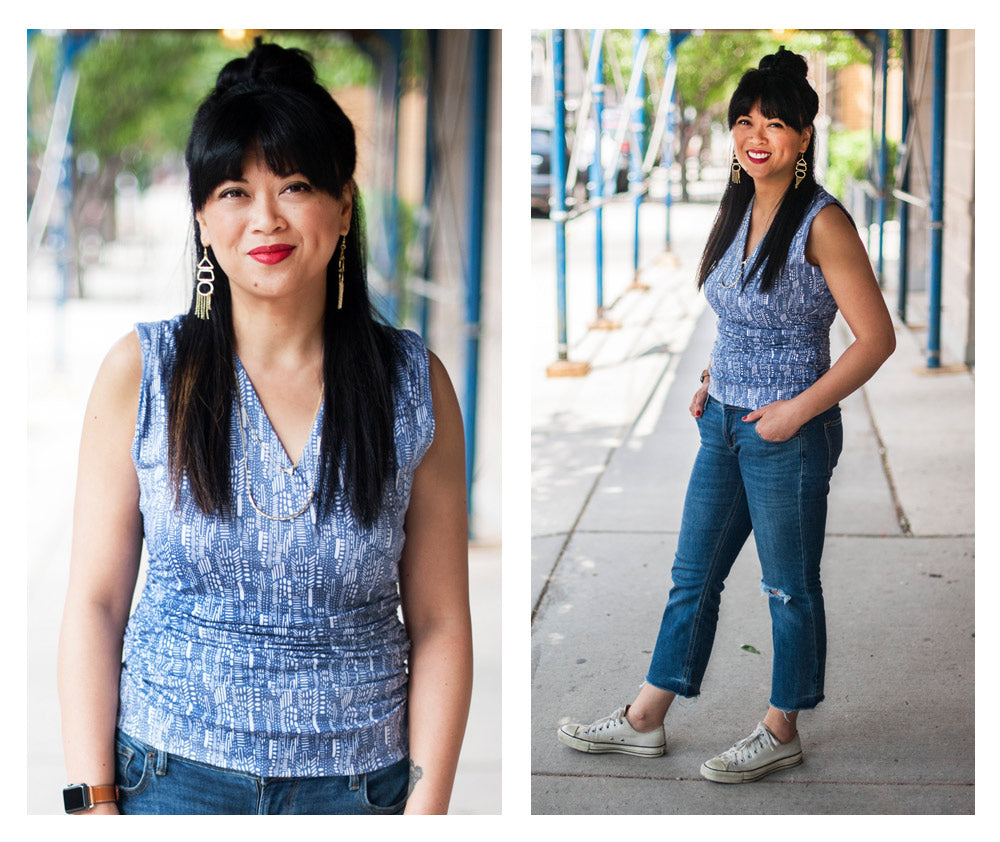 Bernadette wearing the Zoya Wrap top in steel blue, the Highgarden earrings in gold, and the Nadira necklace in white.