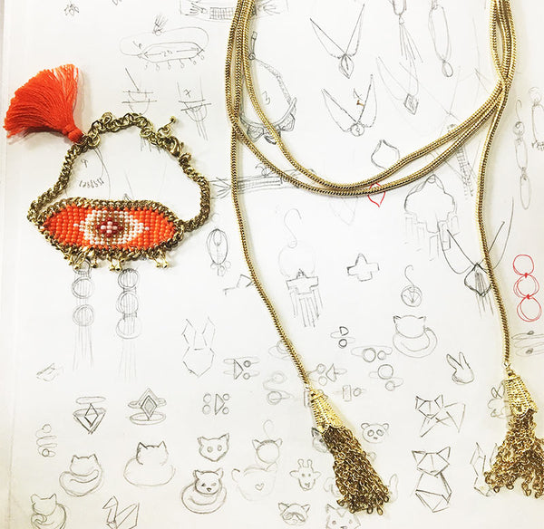 The Kira beaded bracelet and the Gia Rope necklace atop sketches of the jewelry.