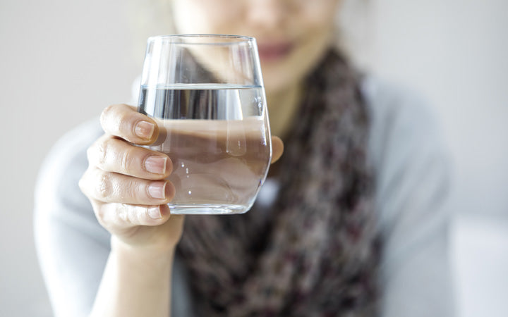 Woman showing glass of water