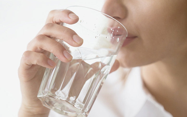 dehydrated woman feeling thirsty holding glass