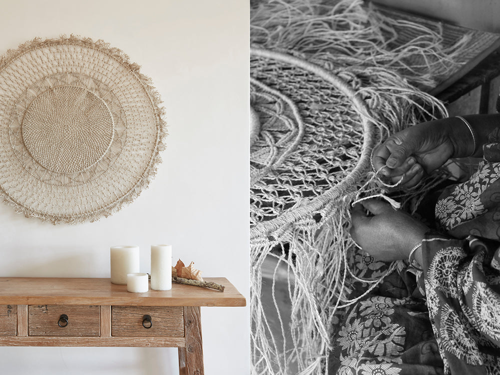 Round mandala wall hanging placed above a wooden table with candles. Fair trade artisan hand weaving decorative tassles for a round jute wall hanging.