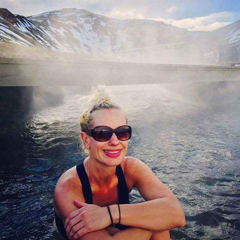 Headshot of Maggie Z. Miller, Co-founder of Magnify Impact with snow-covered mountains and steam in background.