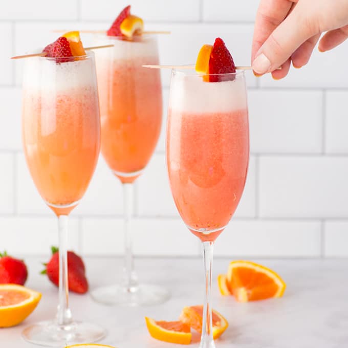 strawberry orange mimosas in champagne flutes